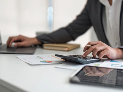 person using a calculator and laptop (1)