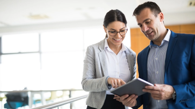 Two business people discussing business strategy using a tablet
