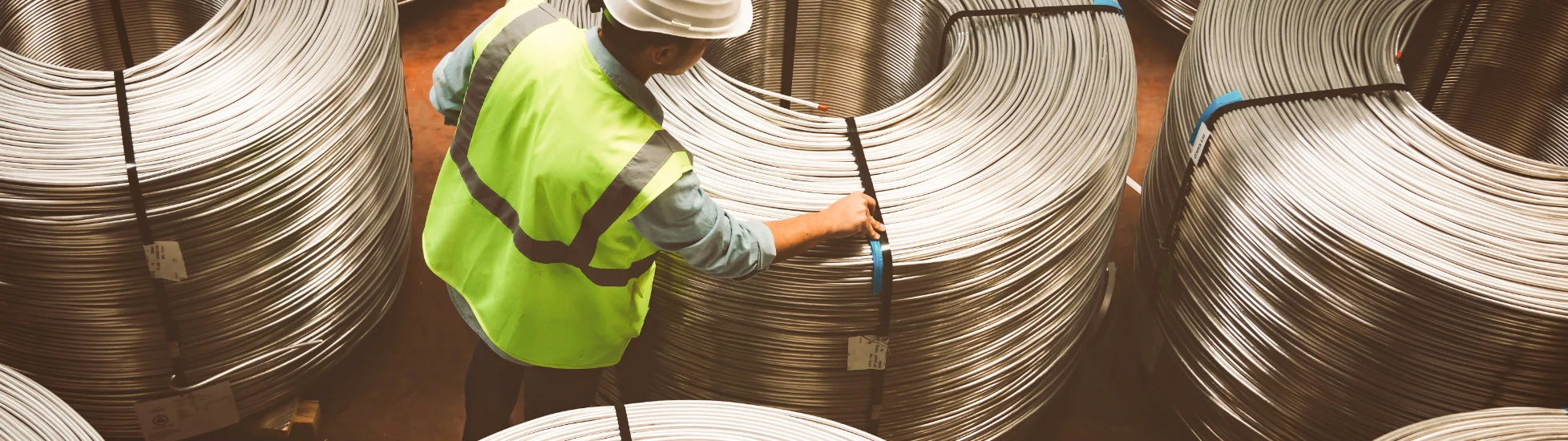Male worker examining metal coils