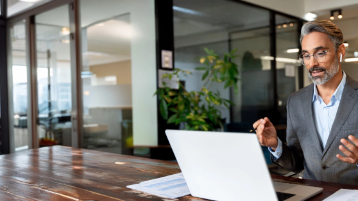 middle aged man taking a business meeting from his laptop