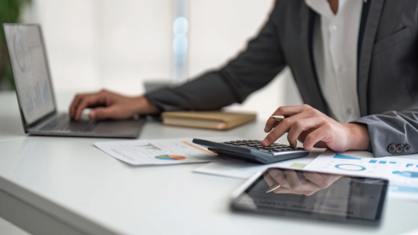 person using a calculator and laptop (1)
