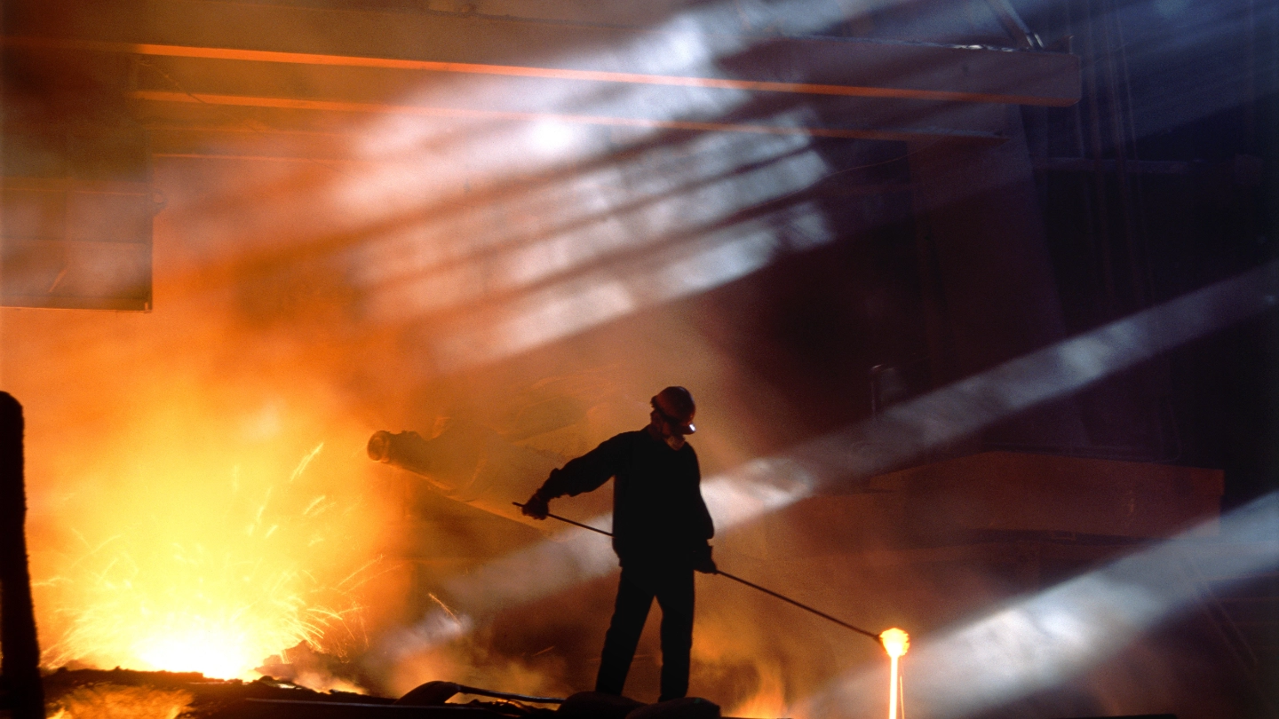 Smelting worker moving ore in landscape shot