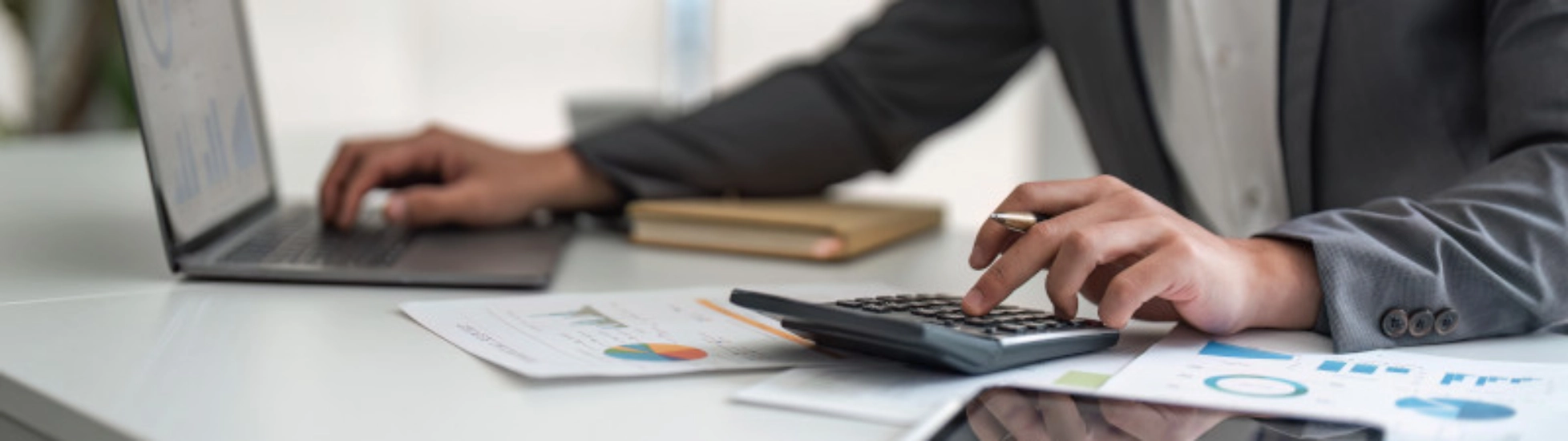 person using a calculator and laptop (1)